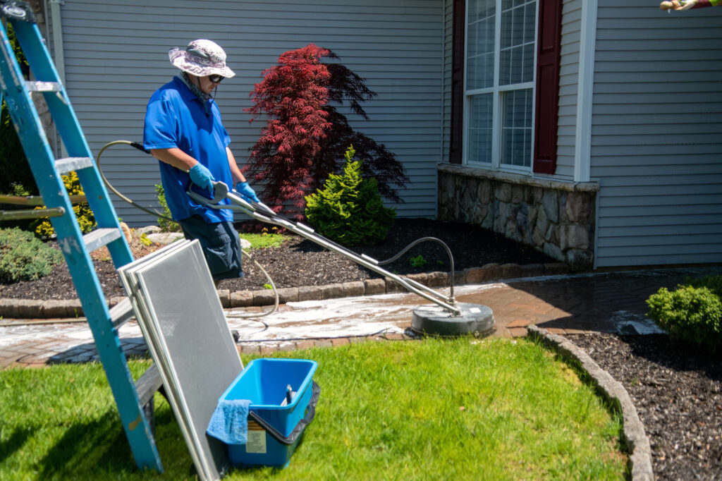 Estate driveway restoration using a professional-grade surface cleaner to provide a uniform, spotless finish on stone pavers.