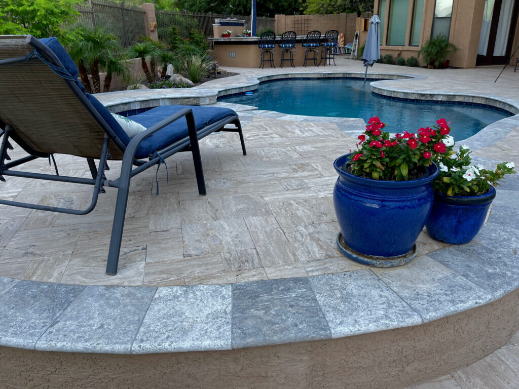 Elite patio cleaning and restoration for a luxury outdoor living space, featuring deep-cleaned travertine pavers and pool surrounds.